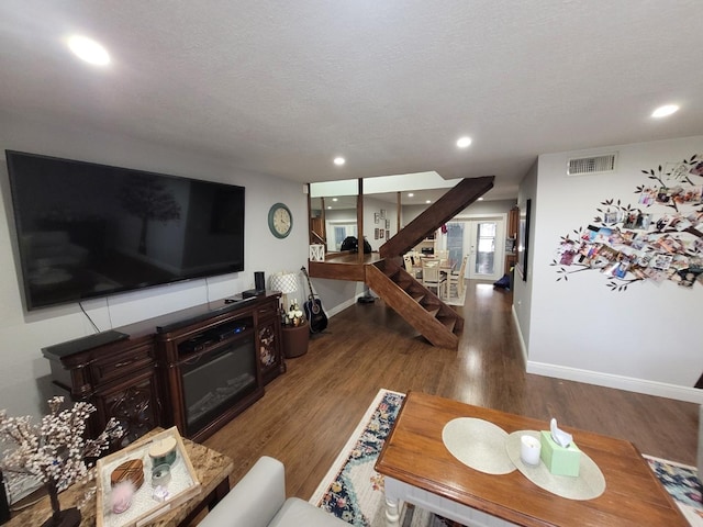 living room with hardwood / wood-style floors and a textured ceiling