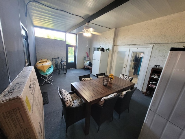 dining space featuring ceiling fan, beam ceiling, and french doors