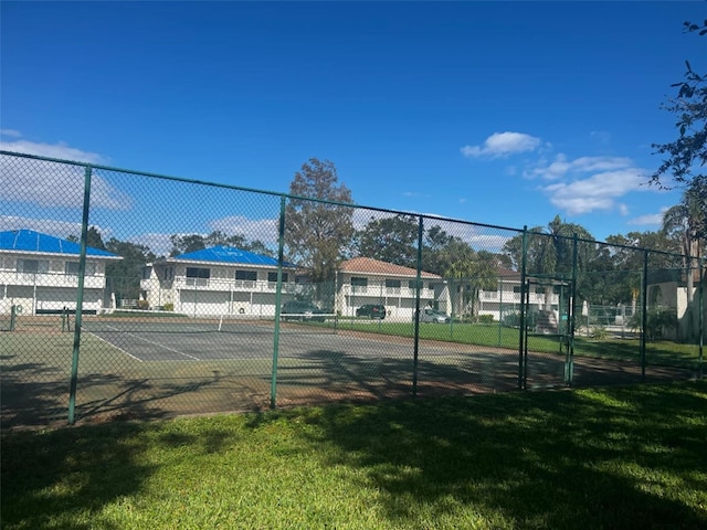 view of sport court with a lawn