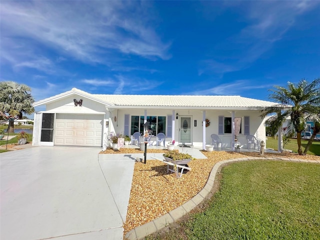 ranch-style house featuring covered porch, a front yard, and a garage