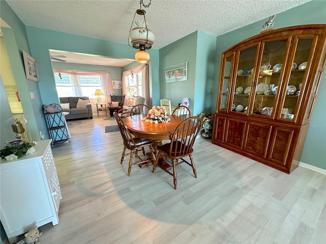 dining area featuring a textured ceiling and light wood-type flooring