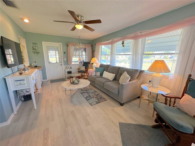 living room featuring light wood-type flooring, a textured ceiling, and ceiling fan