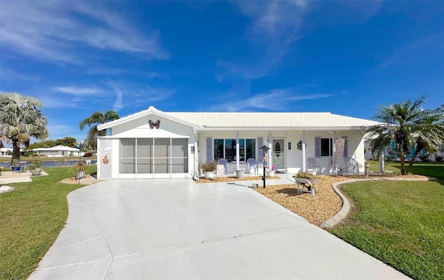 ranch-style home featuring a porch, a garage, and a front yard