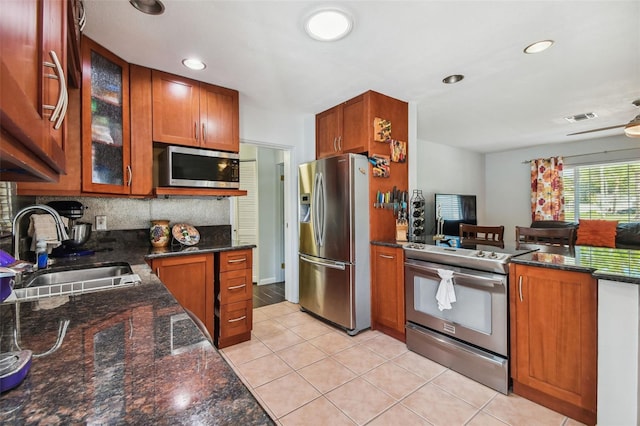 kitchen with stainless steel appliances, a sink, visible vents, decorative backsplash, and glass insert cabinets
