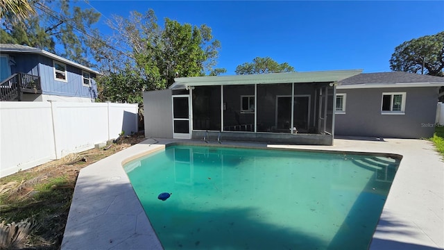 view of swimming pool with a sunroom, fence, a patio, and a fenced in pool