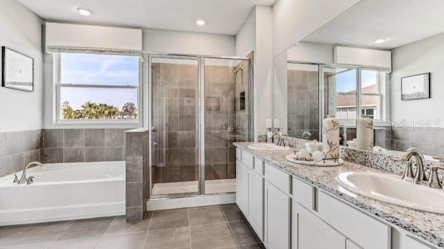 bathroom featuring shower with separate bathtub, vanity, and tile patterned floors