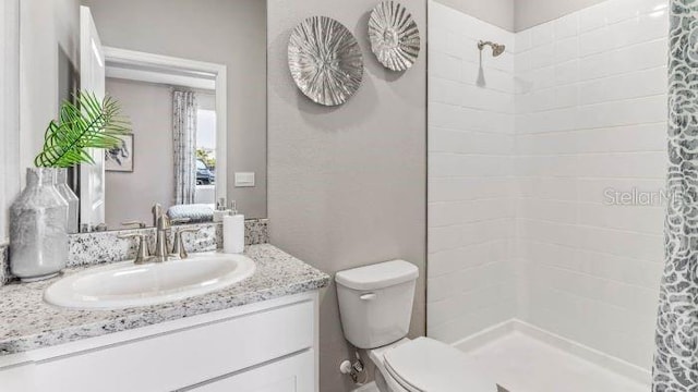 bathroom featuring vanity, toilet, and walk in shower