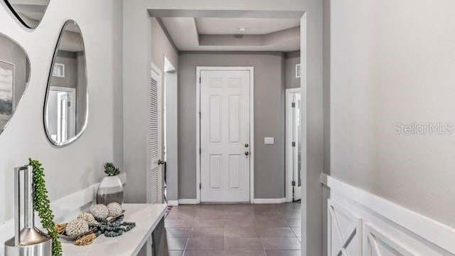 16026 10th Ave E, Bradenton, FL 34212 - entrance foyer with a tray ceiling, dark tile patterned flooring, and baseboards