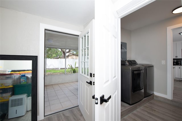 clothes washing area with separate washer and dryer and light hardwood / wood-style flooring