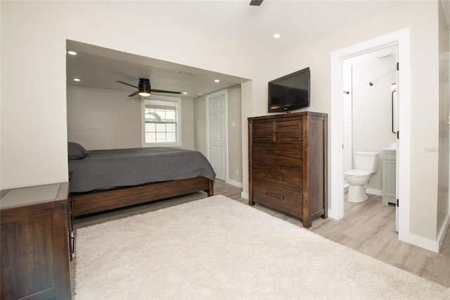 bedroom with light wood-type flooring, connected bathroom, and ceiling fan