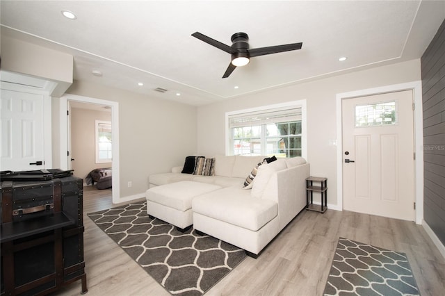 living room with light wood-type flooring and ceiling fan