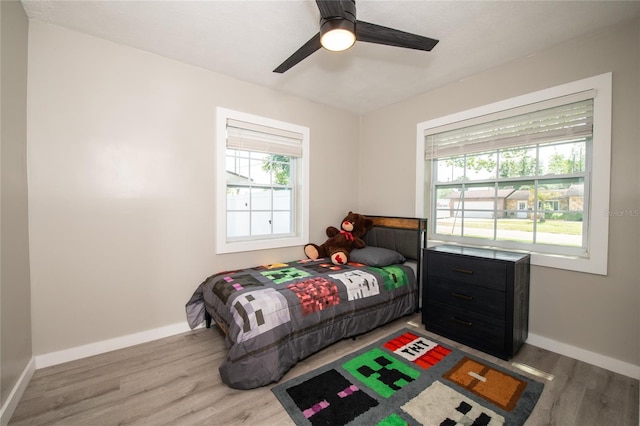 bedroom featuring light hardwood / wood-style floors, multiple windows, and ceiling fan