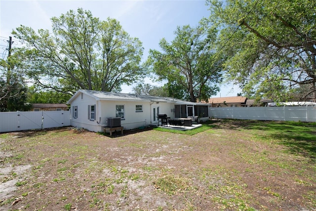 back of property with a lawn, a patio area, and central air condition unit