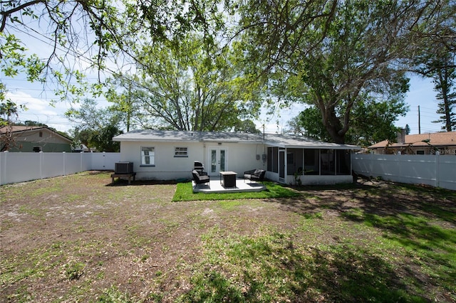 back of house with a sunroom, a yard, french doors, central AC unit, and a patio