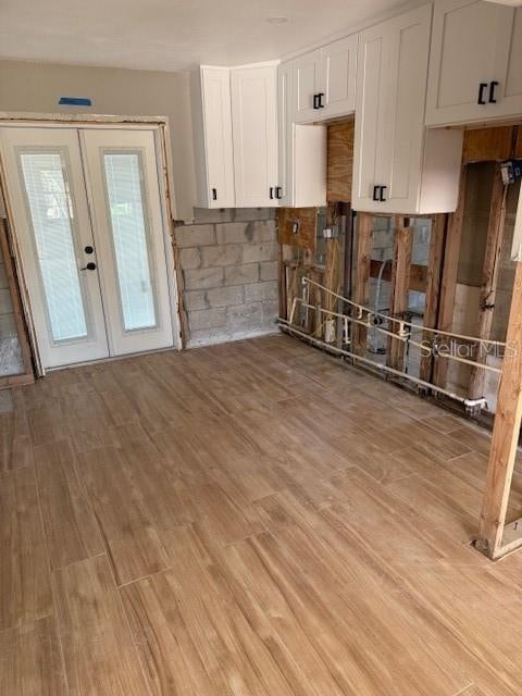 kitchen featuring french doors, white cabinets, and light hardwood / wood-style floors