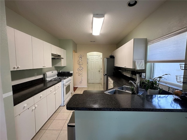 kitchen featuring white cabinets, sink, a textured ceiling, white gas stove, and light tile patterned flooring