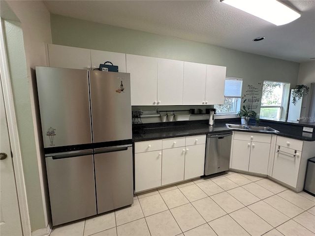 kitchen featuring sink, white cabinets, stainless steel appliances, and light tile patterned floors