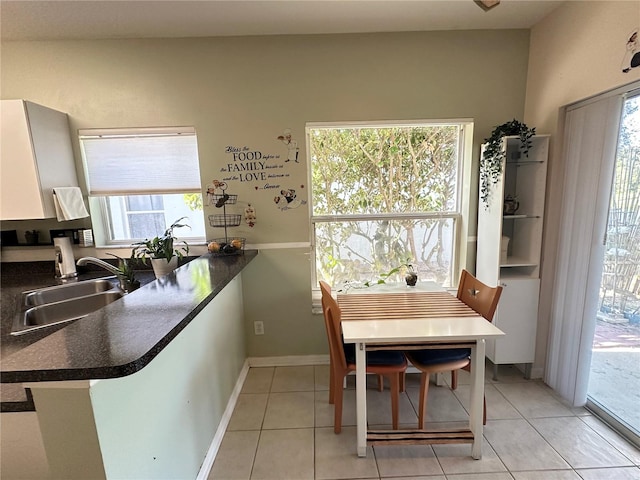 dining area featuring light tile patterned flooring, plenty of natural light, and sink