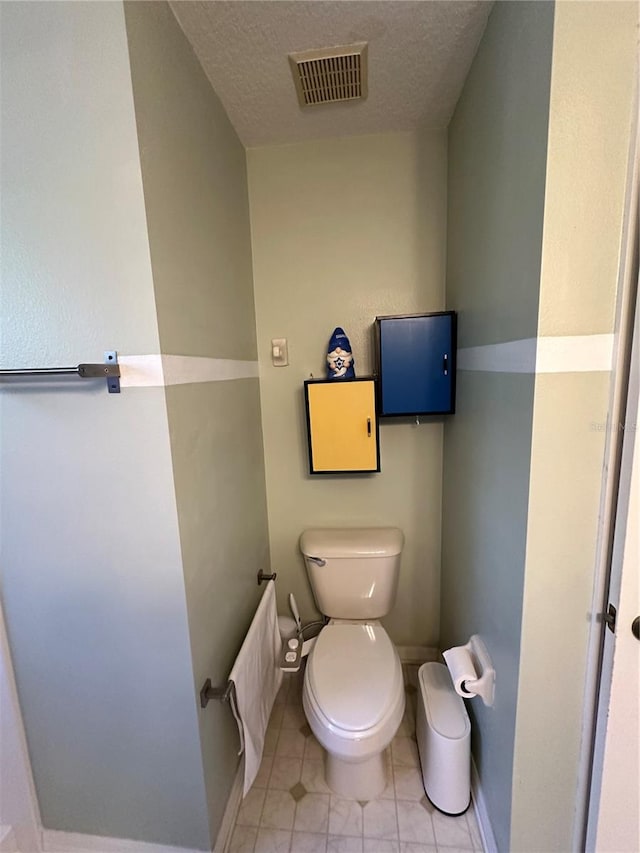 bathroom featuring tile patterned floors, radiator, a textured ceiling, and toilet