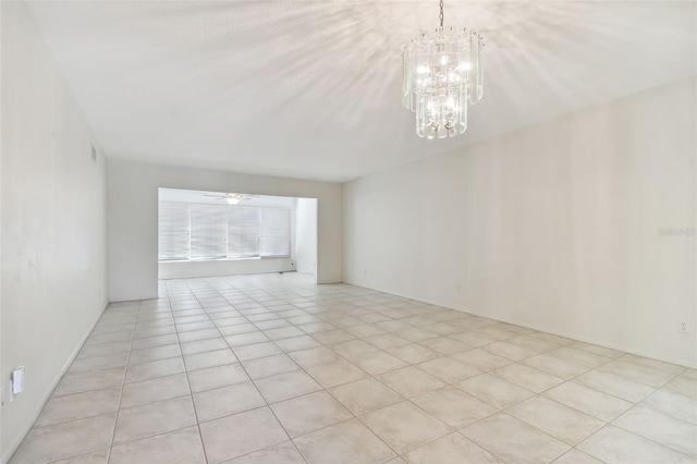 unfurnished room featuring ceiling fan with notable chandelier and light tile patterned floors