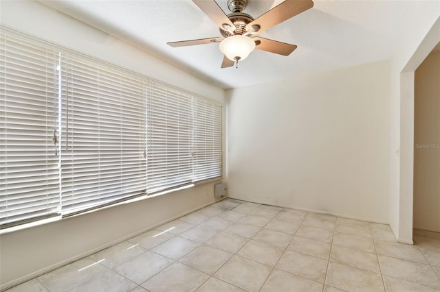 unfurnished room featuring ceiling fan, plenty of natural light, and light tile patterned flooring