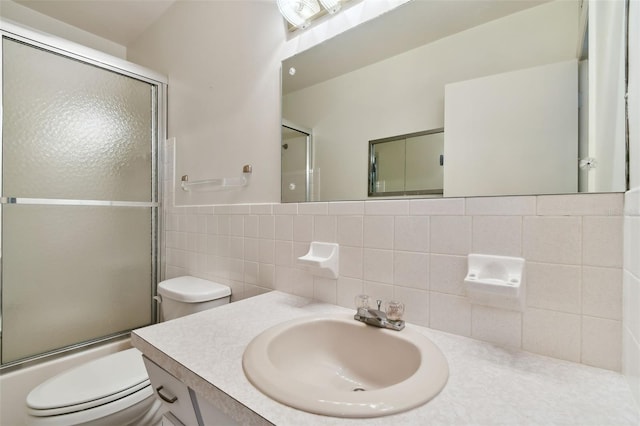 full bathroom featuring vanity, decorative backsplash, toilet, enclosed tub / shower combo, and tile walls