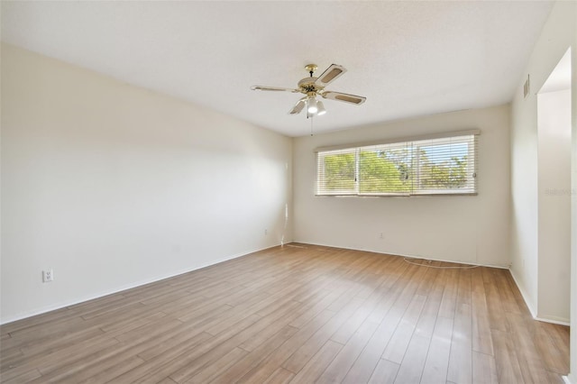 spare room featuring light wood-type flooring and ceiling fan