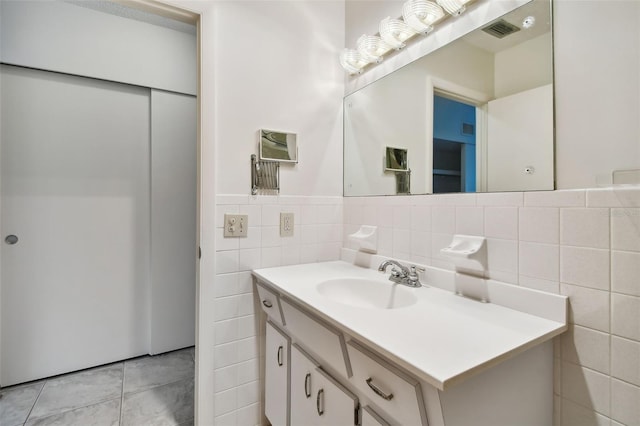 bathroom featuring vanity, tile patterned floors, and tile walls