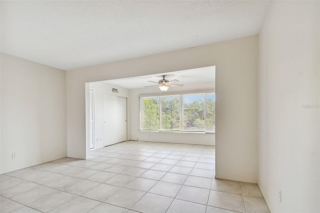 tiled empty room featuring ceiling fan