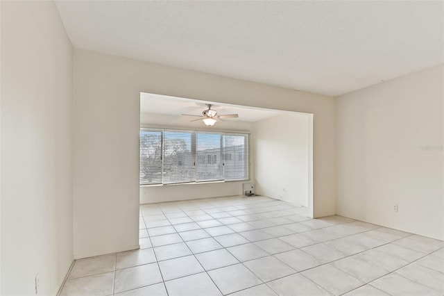 tiled spare room with ceiling fan