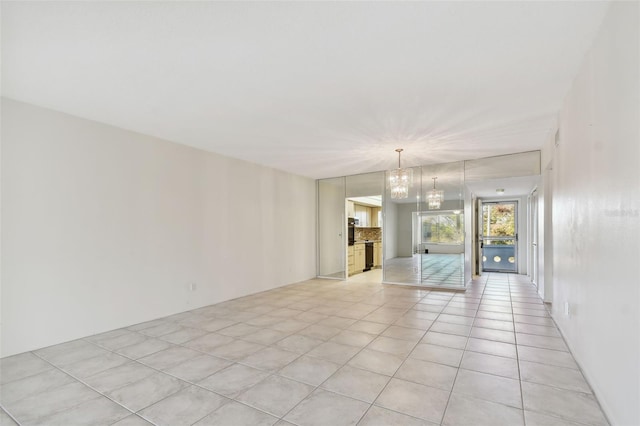 unfurnished room featuring light tile patterned flooring and a chandelier