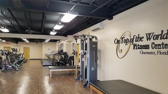 workout area with a wall mounted air conditioner and hardwood / wood-style flooring