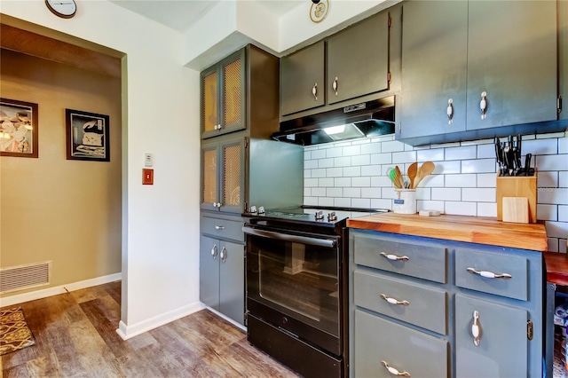 kitchen with wood counters, electric range, dark hardwood / wood-style floors, and backsplash