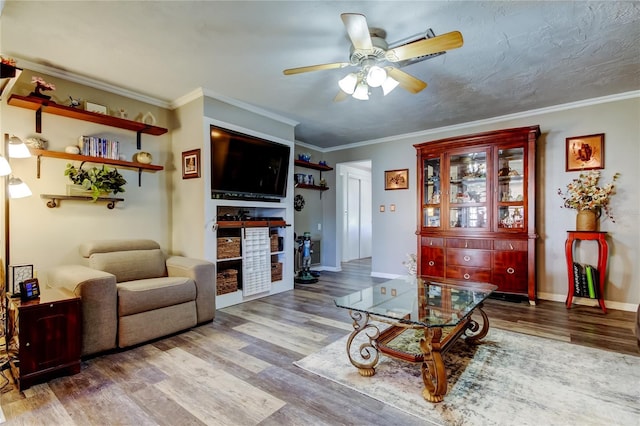 living room with hardwood / wood-style flooring, ceiling fan, and crown molding