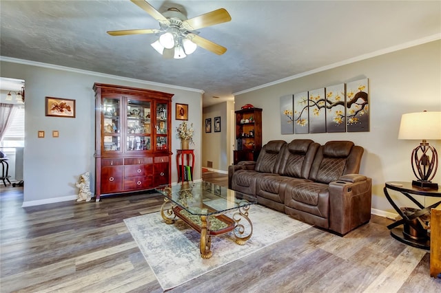 living room with wood-type flooring, ceiling fan, and crown molding