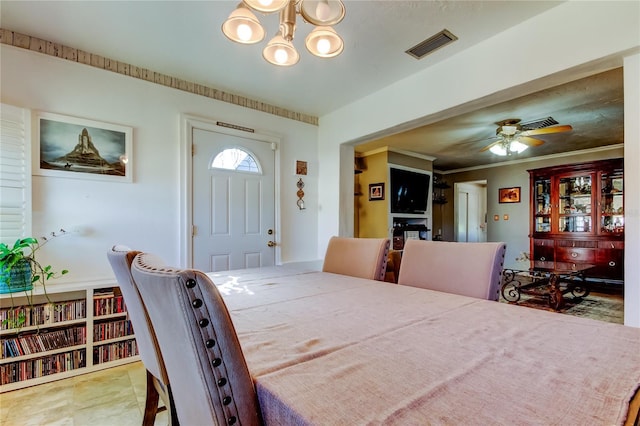 dining room with ceiling fan with notable chandelier and crown molding