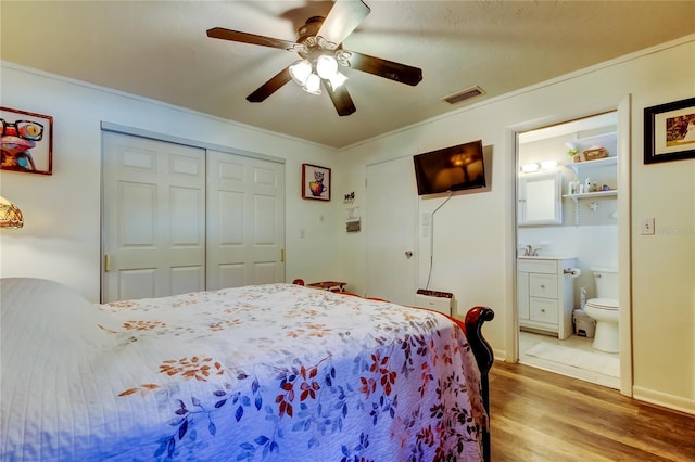 bedroom featuring ensuite bathroom, ornamental molding, ceiling fan, sink, and hardwood / wood-style flooring