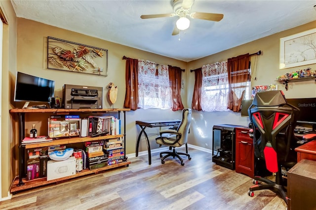 home office featuring light hardwood / wood-style floors and ceiling fan