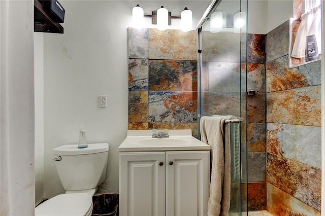 bathroom featuring vanity, toilet, and a shower with door