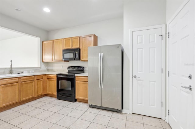 kitchen with black appliances, light tile patterned floors, and sink