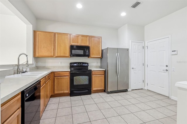 kitchen featuring sink, light tile patterned floors, and black appliances