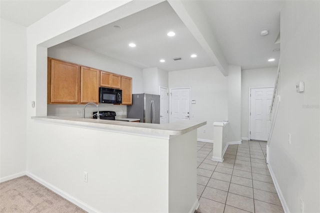 kitchen with black appliances, beam ceiling, kitchen peninsula, and light tile patterned floors