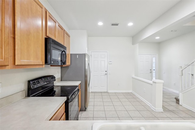 kitchen with light tile patterned flooring and black appliances