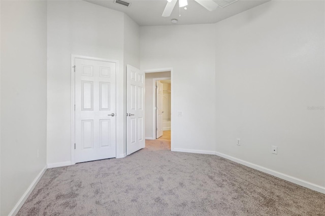 unfurnished bedroom with light colored carpet, high vaulted ceiling, and ceiling fan