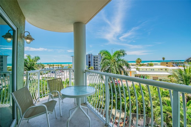 balcony featuring a view of the beach and a water view