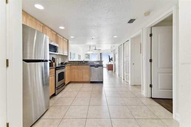 kitchen featuring kitchen peninsula, a textured ceiling, stainless steel appliances, sink, and light brown cabinets