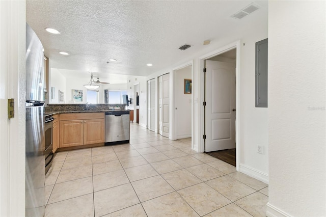 kitchen featuring dishwasher, light tile patterned floors, and a textured ceiling