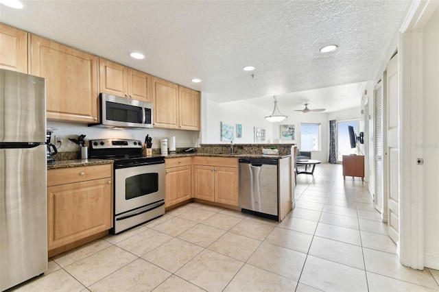 kitchen with ceiling fan, stainless steel appliances, kitchen peninsula, a textured ceiling, and decorative light fixtures