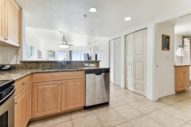 kitchen with sink, stainless steel appliances, decorative light fixtures, a textured ceiling, and light tile patterned floors