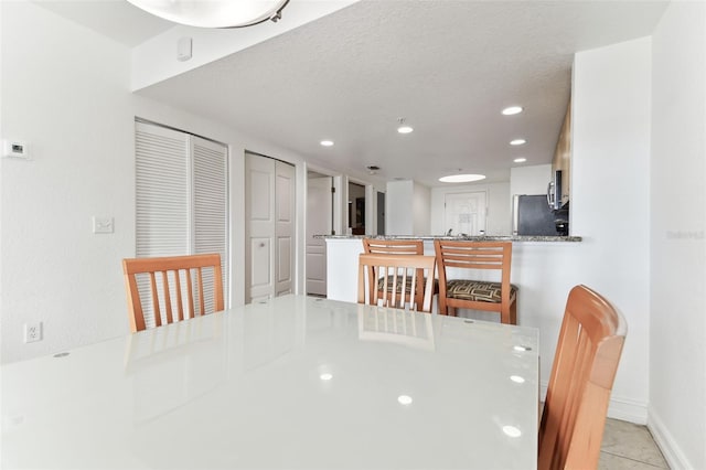 tiled dining room with a textured ceiling